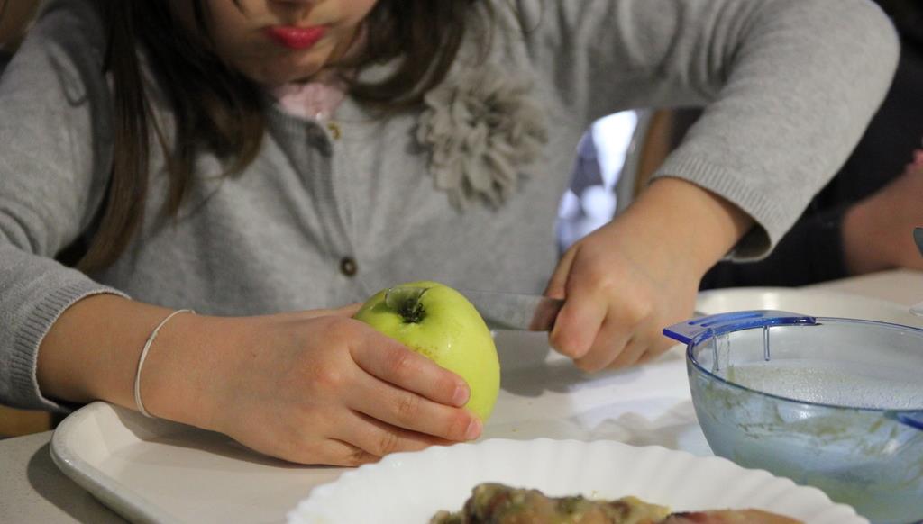 enfant coupant une pomme